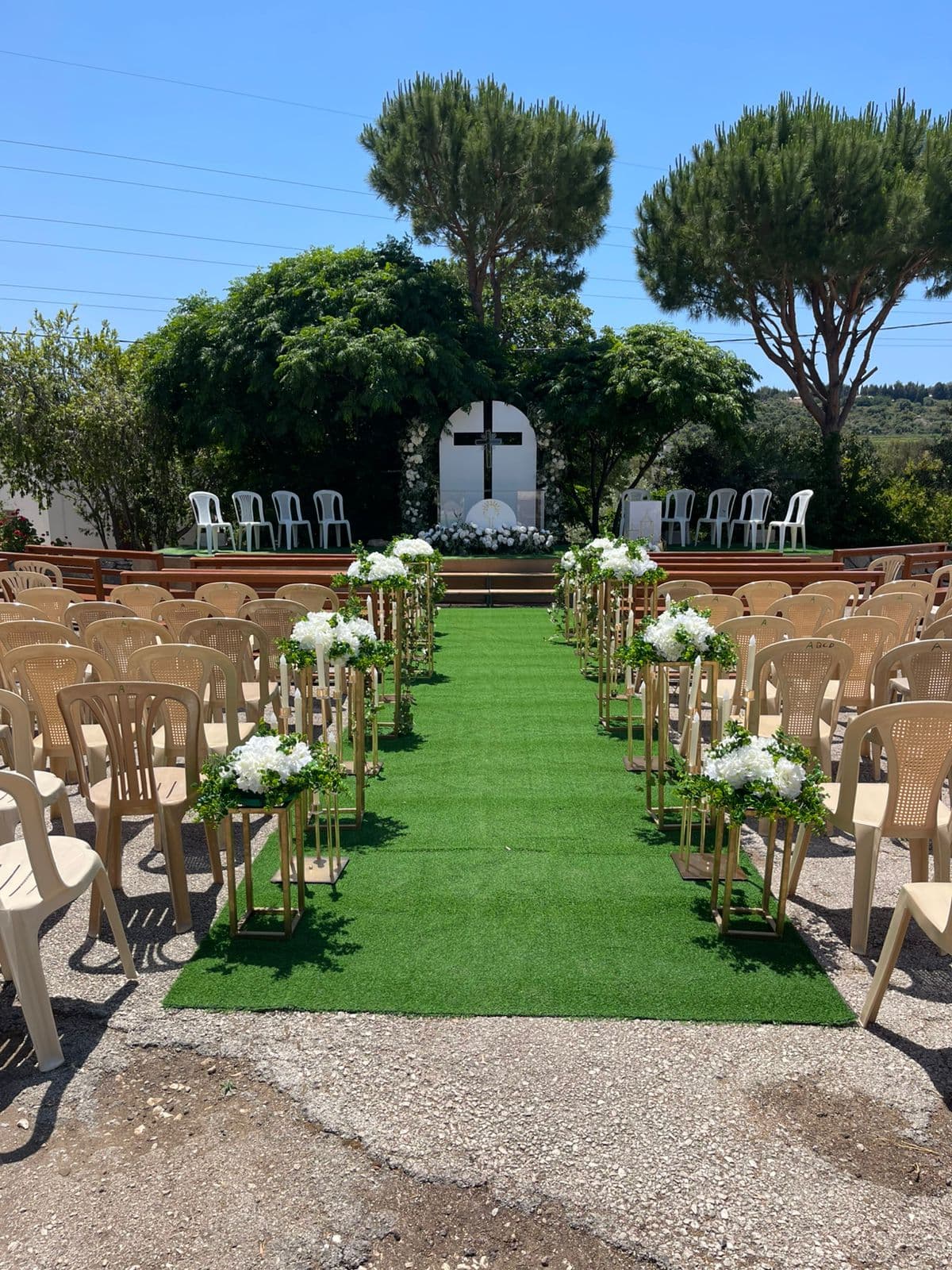 Outdoor ceremony aisle lined with white hydrangeas